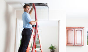 a man on a ladder on a ladder holding a tube